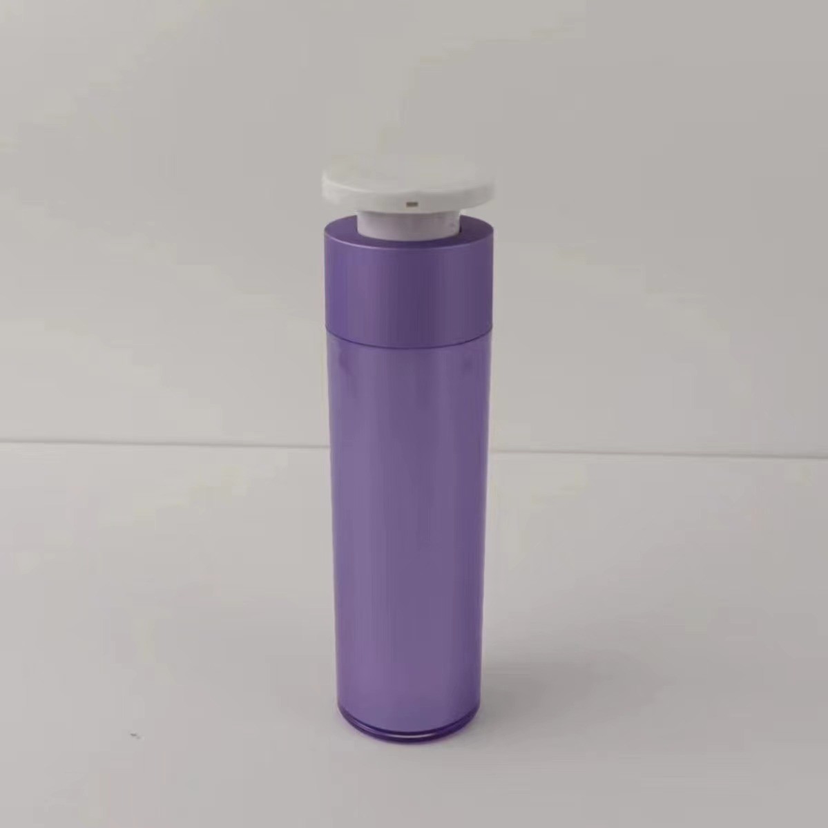 Botella de plástico púrpura para dispensadores de cosméticos con bomba de presión blanca